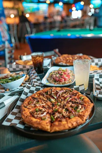 The dining room at The Nut House — screens, pizza.